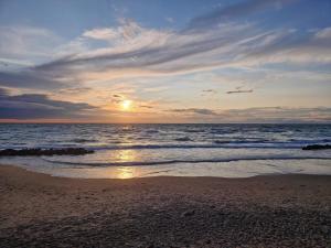 - un coucher de soleil sur une plage donnant sur l'océan dans l'établissement 6 person holiday home in Hjørring-By Traum, à Vester Vidstrup