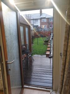 an open door to a deck with a view of a yard at Private Self Contained Annex/Cabin in Birmingham