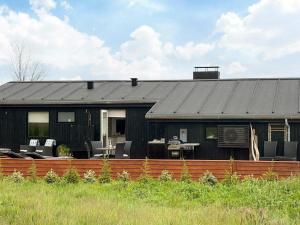 a black house with a fence in front of it at 6 person holiday home in Sjølund-By Traum in Binderup Strand
