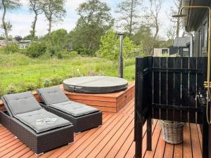 a deck with two wicker chairs and a fire pit at 6 person holiday home in Sjølund-By Traum in Binderup Strand
