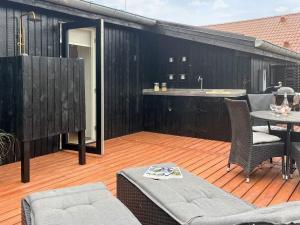 a patio with a table and chairs on a deck at 6 person holiday home in Sjølund-By Traum in Binderup Strand