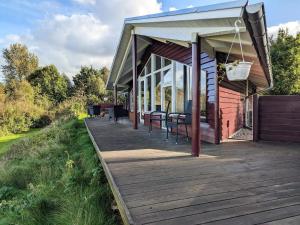 a wooden deck with tables and chairs on a house at 6 person holiday home in Højslev-By Traum in Bøstrup