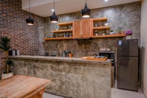 Una cocina con gabinetes de madera y un refrigerador de acero inoxidable. en Kidupa Villa 2 BR private pool, en Ubud