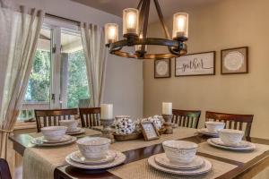 a dining room with a table with a chandelier at Memorable "Deer & Doe" by HoneyBearCabins 4BR 3BA, Mountain View Deck, Farmhouse Decor, Fireplace, 3 Acres in Sevierville
