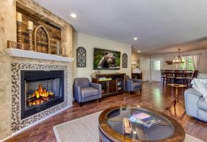 a living room with a fireplace and a couch at Memorable "Deer & Doe" by HoneyBearCabins 4BR 3BA, Mountain View Deck, Farmhouse Decor, Fireplace, 3 Acres in Sevierville