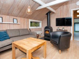 a living room with a couch and a wood stove at 6 person holiday home in Ebeltoft-By Traum in Ebeltoft