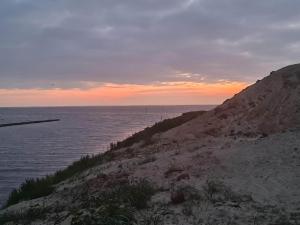 una puesta de sol sobre el océano en una orilla rocosa en 6 person holiday home in Tarm-By Traum, en Tarm 31 fotos más