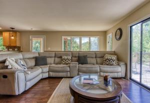 a living room with a couch and a table at Memorable "Deer & Doe" by HoneyBearCabins 4BR 3BA, Mountain View Deck, Farmhouse Decor, Fireplace, 3 Acres in Sevierville