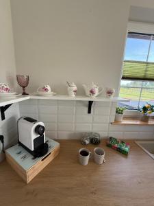 a kitchen with a microwave and cups on the floor at Warmia Domek Bukowy in Woryty