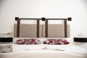 a bed with two red pillows on top of it at La Villa 91 in Monastir +37 photos