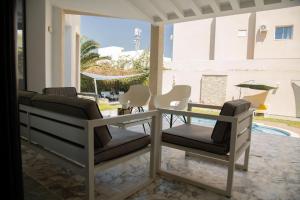 a patio with chairs and a table and a pool at La Villa 91 in Monastir