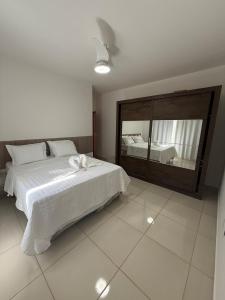 une chambre avec un lit et un grand miroir dans l'établissement Casa aconchegante e cheirosa, à Nanuque