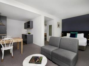 a hotel room with a bed and a couch and a table at Mantra MacArthur Hotel in Canberra +116 photos