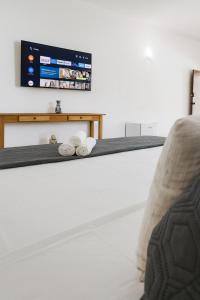 a living room with a tv on a wall at POUSADA ARUÁ PARATY - ''Novidade'' in Paraty