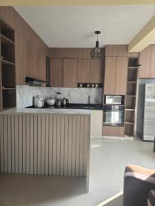 a kitchen with wooden cabinets and a counter top at Casa con Piscina Pachacamac in Pachacamac
