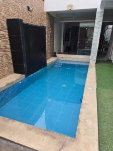 a swimming pool with blue tiles on the ground at Casa con Piscina Pachacamac in Pachacamac
