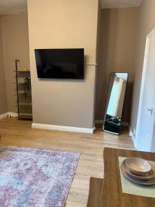 Una sala de estar con un televisor de pantalla plana en una pared. en Cosy Jesmond Retreat!, en Jesmond