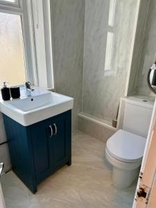 Un baño con lavabo blanco y inodoro. en Cosy Jesmond Retreat!, en Jesmond