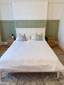 Un dormitorio con una gran cama blanca con dos almohadas. en Cosy Jesmond Retreat!, en Jesmond