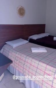 a bedroom with two beds with white pillows at Pousada Aconchego in Aracaju +6 photos