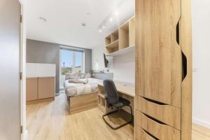 a bedroom with a bed and a desk with a chair at Accessible Student Only Studio In Central Leeds in Elland
