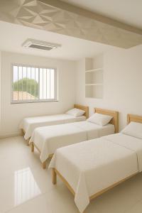 a row of beds in a white room at Casa para cop 30 in Belém