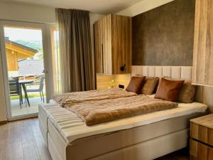 a bedroom with a large bed and a balcony at Grebenzen Lodge Starnberg 60A in Sankt Lambrecht