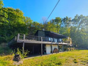 a house with a deck on top of a field at Agathe in Laforêt