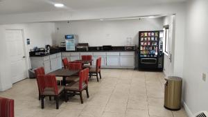 a kitchen with a table and chairs and a refrigerator at Rancho Cordova Inn in Rancho Cordova