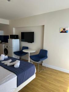 a bedroom with a bed and two chairs and a table at Sunny Sea View Aparthotel in Orbi City Batumi in Batumi