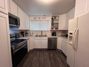 a kitchen with white cabinets and black appliances at Sunny Days in Pocatello