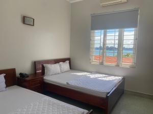 a bedroom with two beds and a window at Sao Mai Hotel Hạ Long in Ha Long
