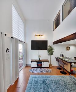a living room with a desk and a tv on the wall at Stylish Two-Story Loft with Rooftop Deck in Vancouver