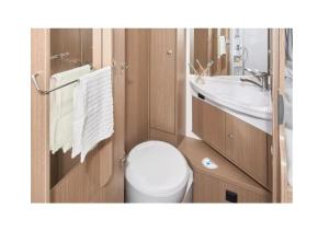 a small bathroom with a toilet and a sink at Caravan Tiny House Base Camp Granada Camping in Dúrcal