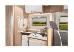 a kitchen with a stove and a sink in an rv at Caravan Tiny House Base Camp Granada Camping in Dúrcal