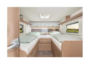 a small bedroom with two beds in an rv at Caravan Tiny House Base Camp Granada Camping in Dúrcal