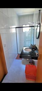 ジャパラティンガにあるCasa recém construída + piscina, próxima da praiaのバスルーム(シンク、赤いスーツケース付)