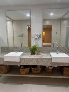a bathroom with two sinks and a large mirror at Gurgueia Palace Hotel in Bom Jesus