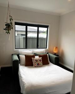 a bedroom with a white bed with a window at Pool, Spa pool, Private, Modern, Clive! in Clive