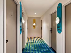 een gang met blauwe en gele vloeren in de gang bij The Clarence Hotel Sydney in Sydney