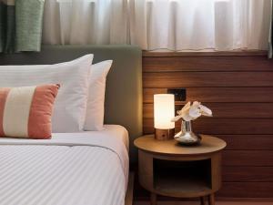 a bedroom with a bed and a lamp on a table at The Clarence Hotel Sydney in Sydney