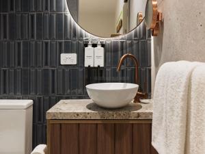 a bathroom with a bowl sink and a mirror at The Clarence Hotel Sydney in Sydney
