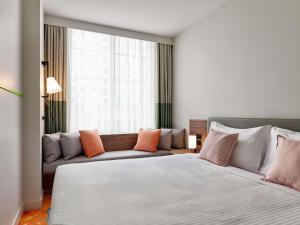 ein Schlafzimmer mit einem großen Bett und einer Couch in der Unterkunft The Clarence Hotel Sydney in Sydney