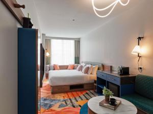 ein Wohnzimmer mit einem Bett und einer Couch in der Unterkunft The Clarence Hotel Sydney in Sydney