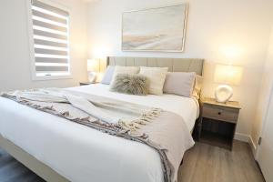 a bedroom with a large white bed and a window at Chappelle with AC King Beds Fenced Yard Garage in Edmonton