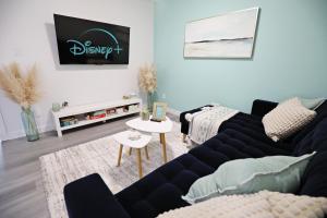 a living room with a couch and a table at Chappelle with AC King Beds Fenced Yard Garage in Edmonton