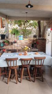 a table with three wooden chairs and a table with at Pousada Plantar e Cuidar in Santa Cruz do Escalvado +97 photos