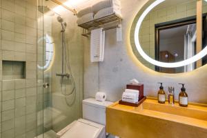 a bathroom with a shower and a toilet and a mirror at Rodona Hotel in Mexico City