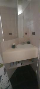 a white bathroom with a sink and a mirror at Bella vista al mar y cerca!! in El Quisco
