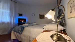 a bedroom with a bed with a lamp on a table at Nottolini House - a 1 minuto dal centro di Lucca in Lucca